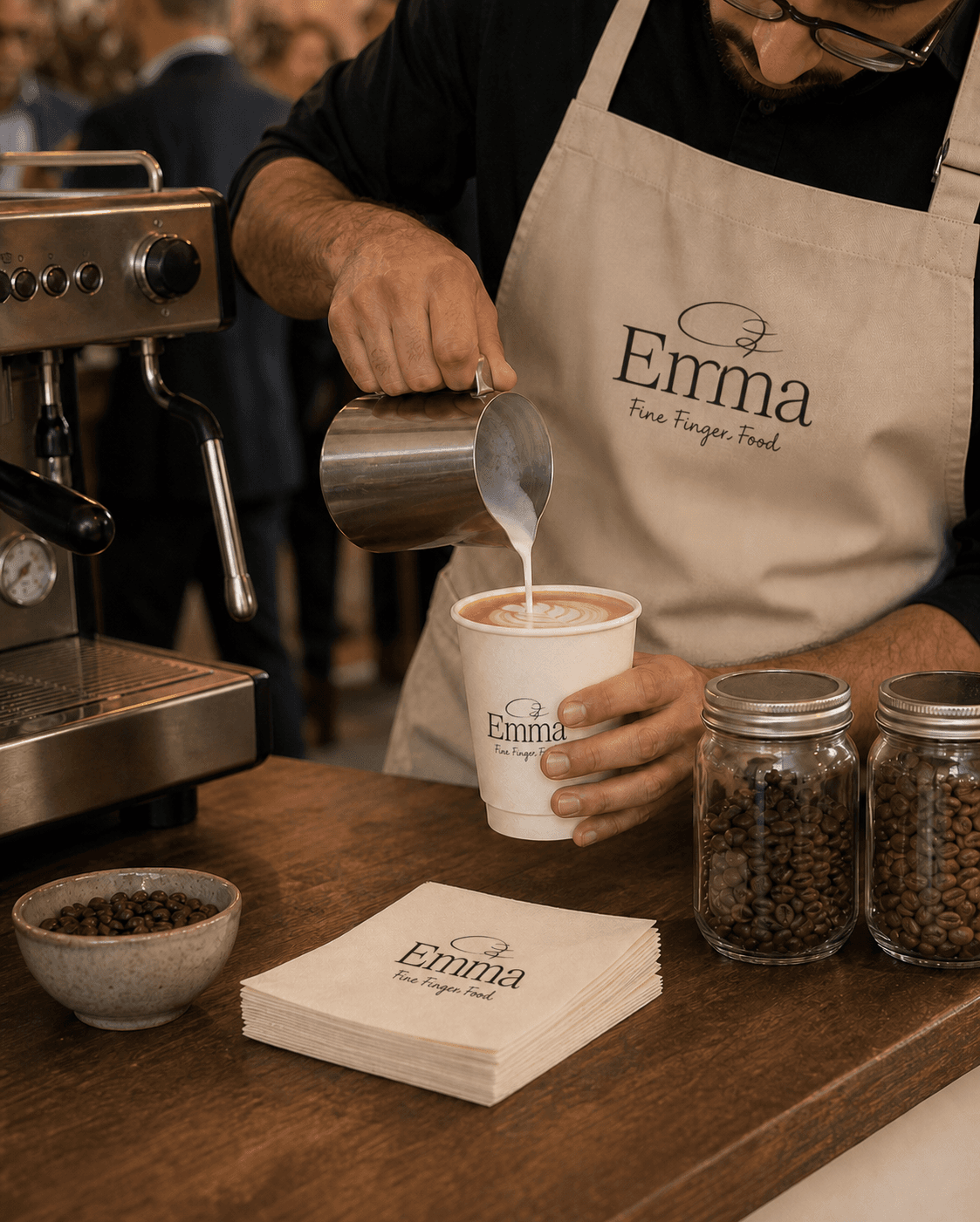 בריסטה של Emma מוזג חלב ומכין לאטה ארט